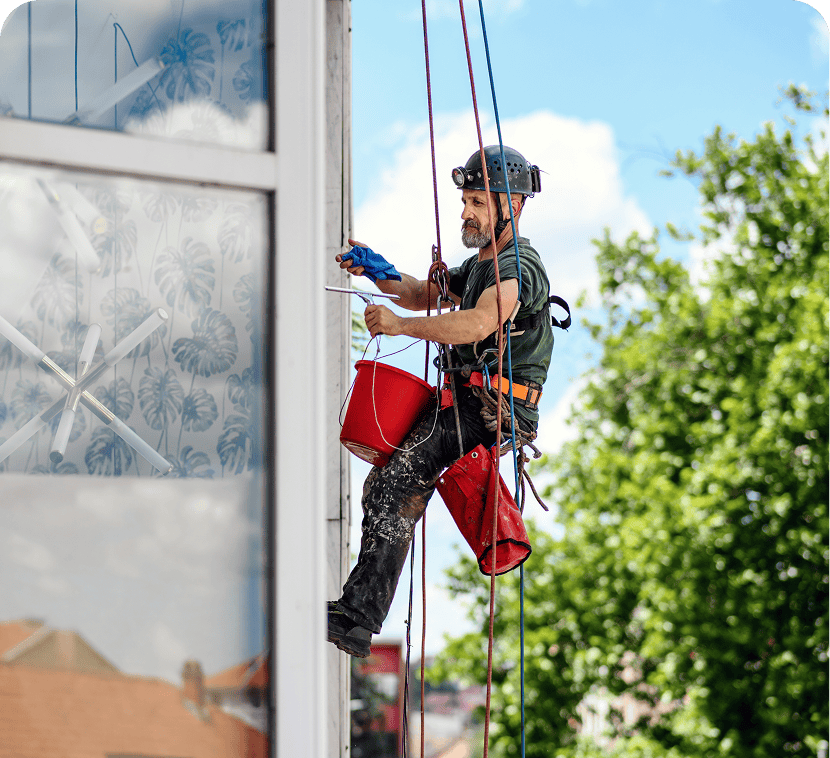 Window cleaner suspended on ropes