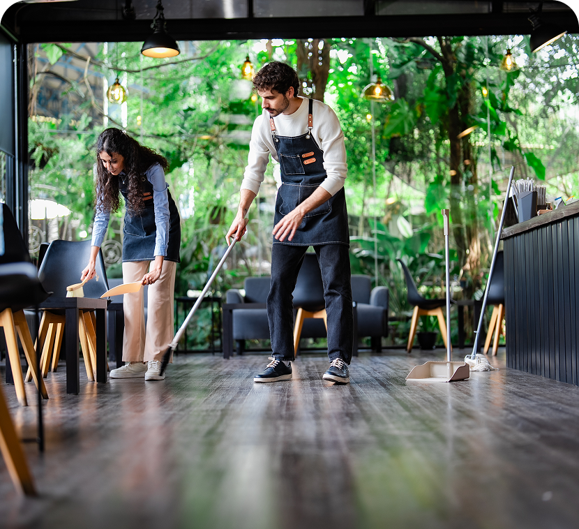 Cafe staff cleaning wooden floor
