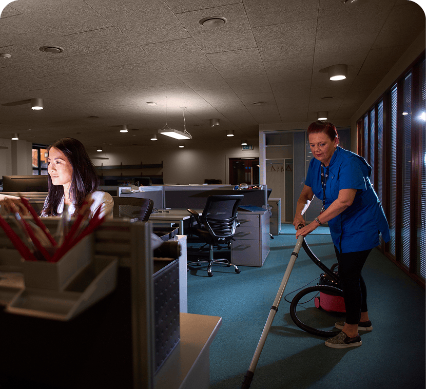 Nighttime office cleaning while employee works late.