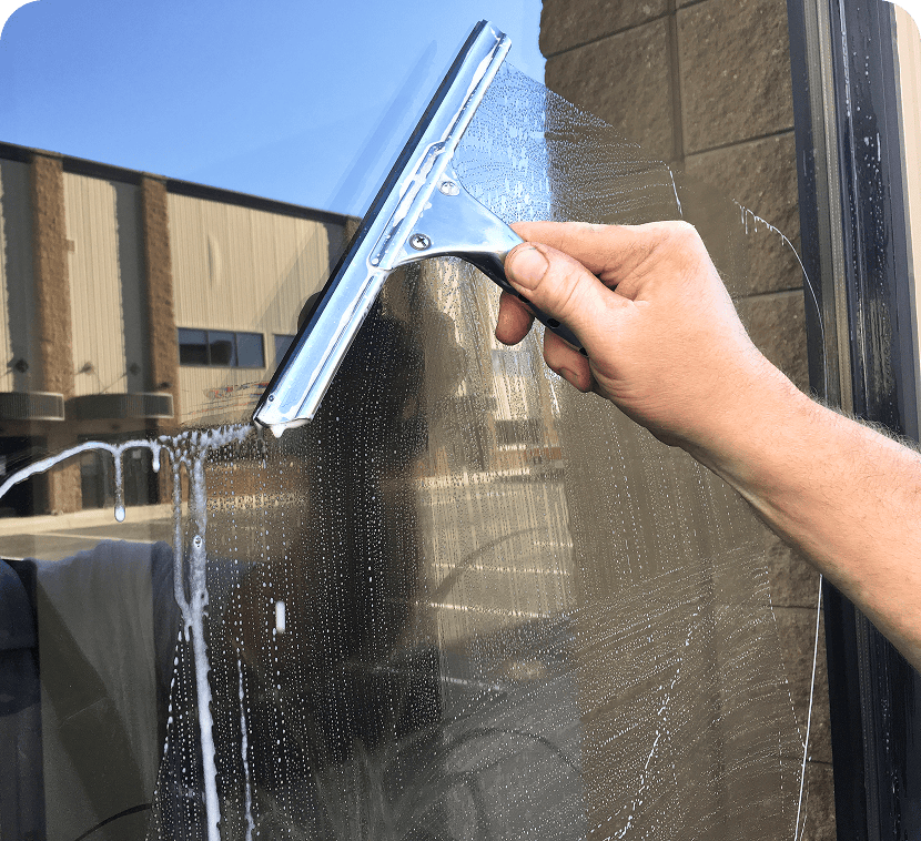 Hand using squeegee on glass