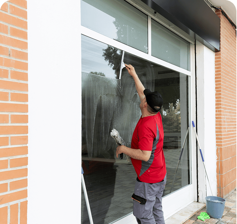 Window cleaner in red shirt working
