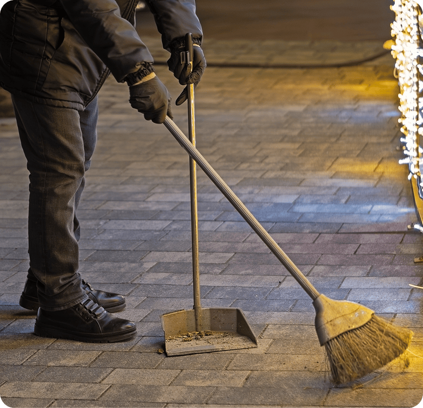 Person cleaning pavement at night