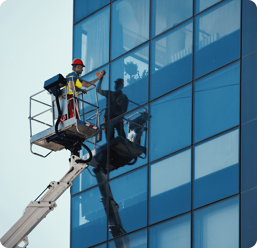 Man on lift cleaning glass building