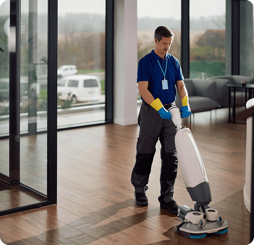 Janitor operating floor scrubber in office