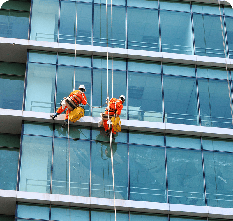 Two men suspended on a skyscraper facade
