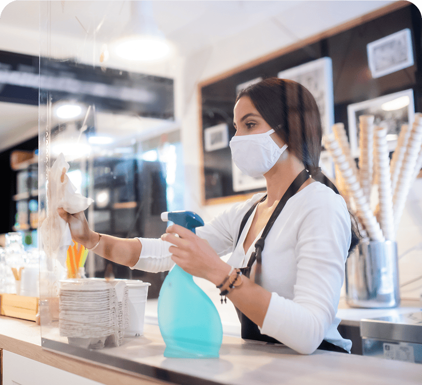 Barista cleaning counter with spray bottle